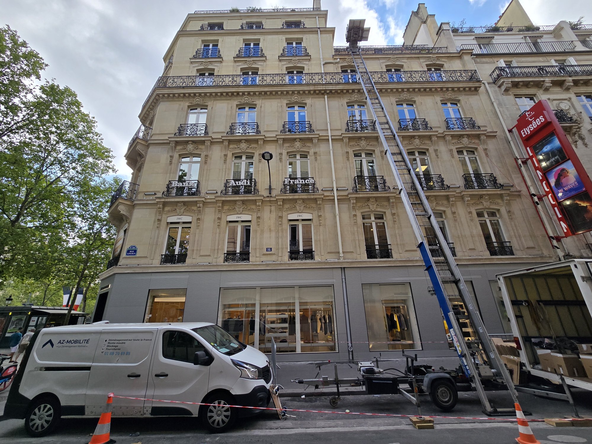 Monte-meubles AZ Mobilité déployé sur la façade d'un immeuble haussmannien du quartier des Champs-Élysées à Paris