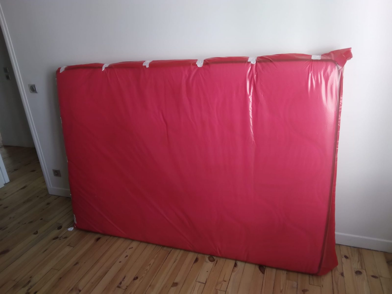 Matelas glissé dans une housse plastique de protection avant transport