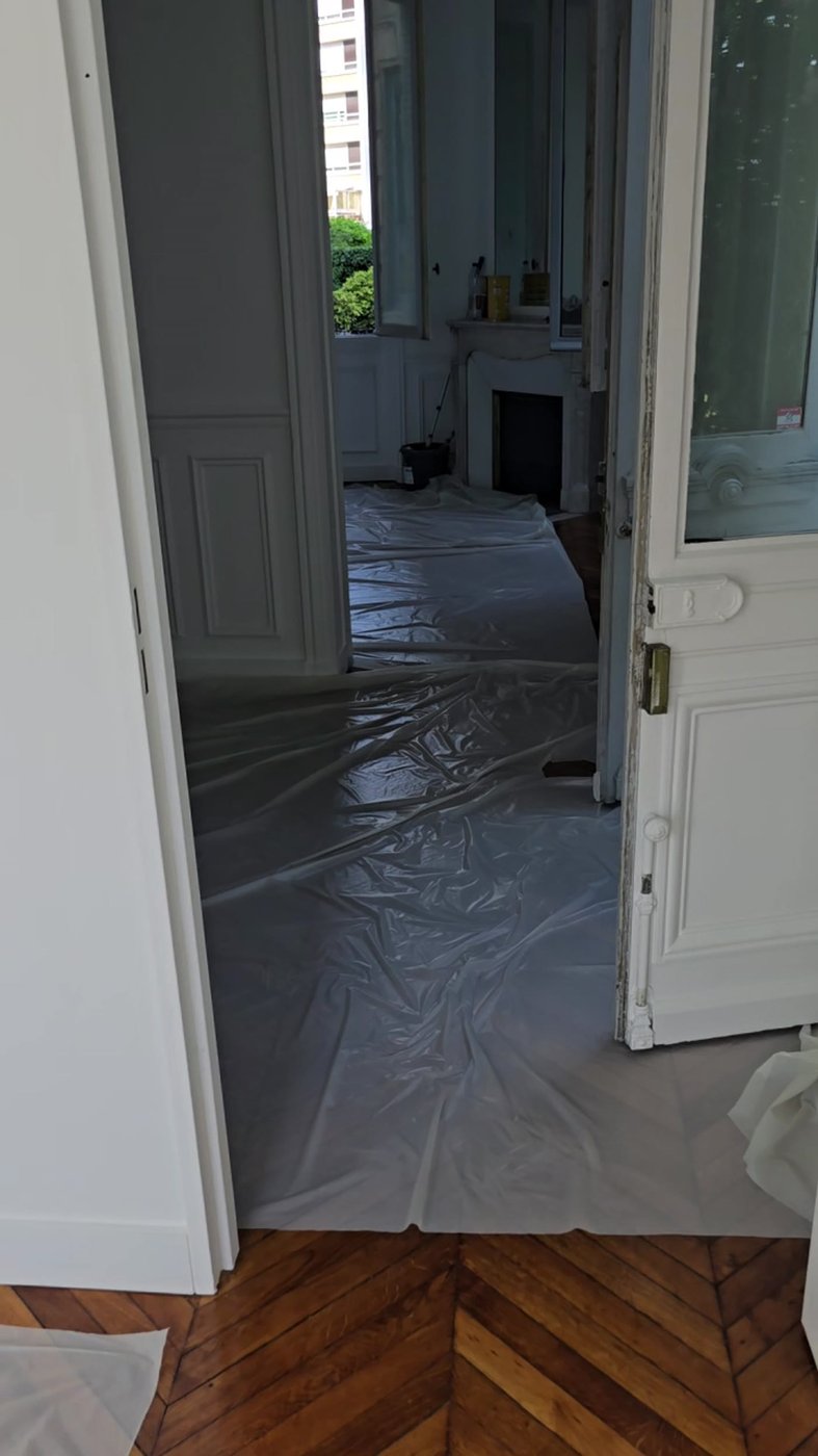 Parquet point de Hongrie protégé par une bâche dans un appartement haussmannien